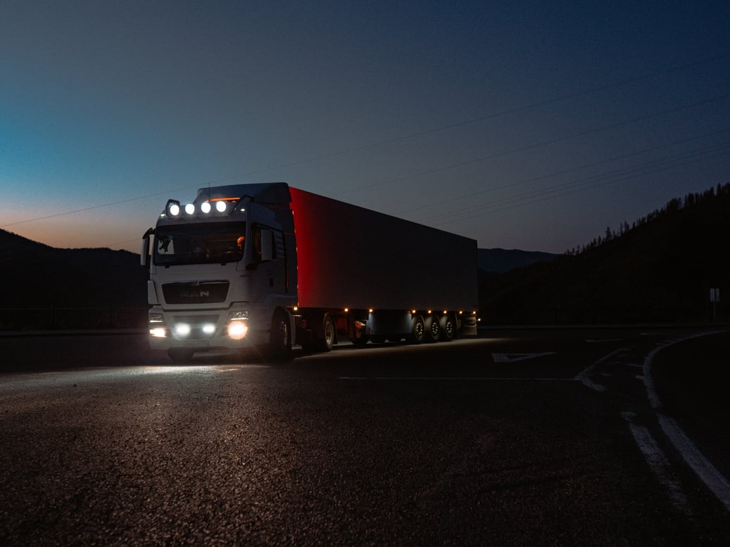 Red and White Freight Truck on Road during Night Time